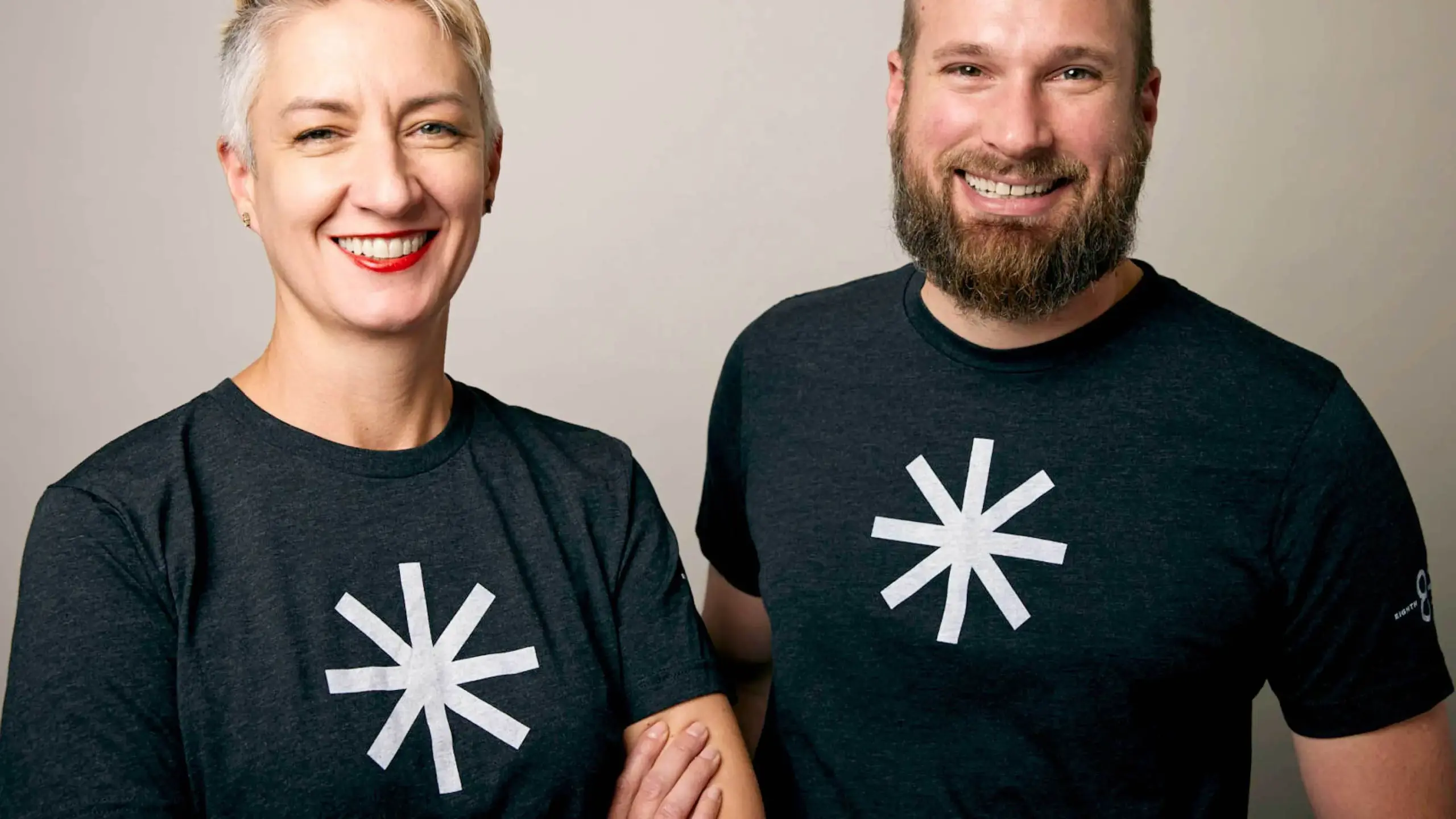 Two people wearing Eighth Light branded t-shirts