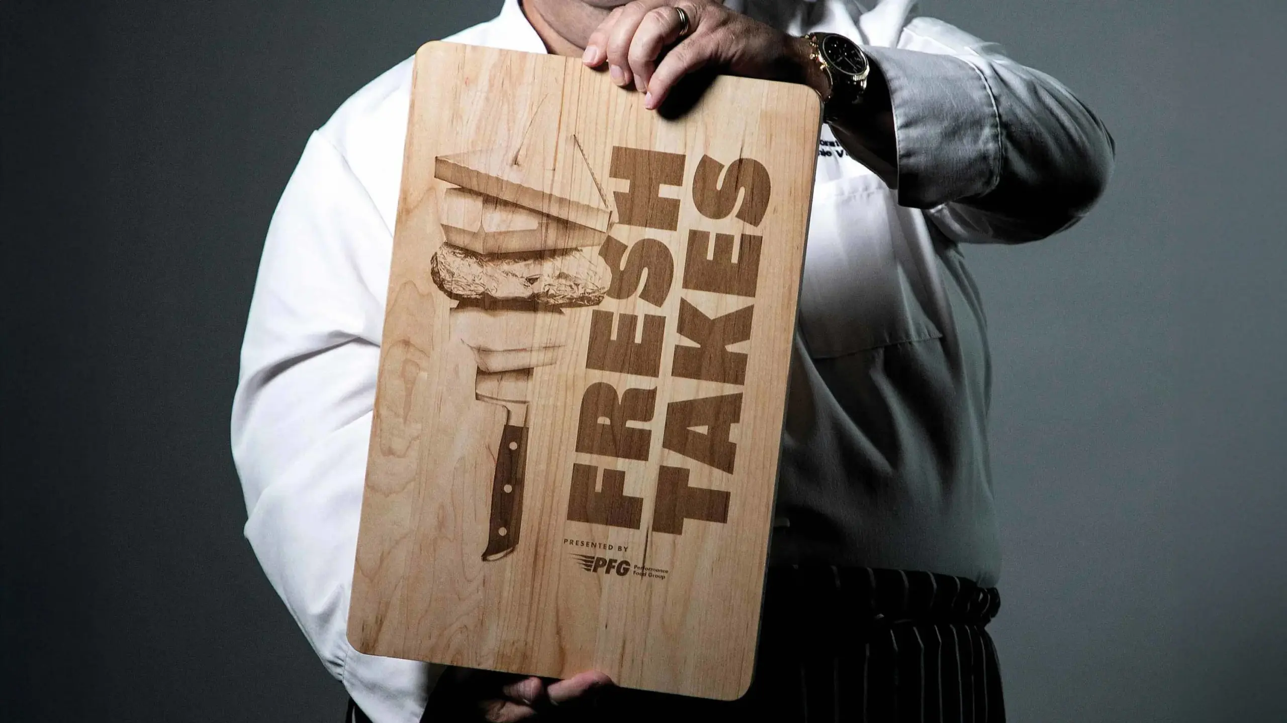 Wooden cutting board with a branded image of the FreshTakes by Performance Food Group branding